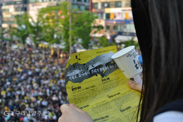 자료사진(2014년 5월 세월호 참사 추모 안산집회에 참석한 한 학생이 안산시민사회연대가 배포한 유인물을 읽고 있다)