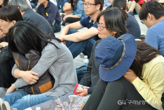 세월호 참사 추모 퍼포먼스 도중 시민들이 차마 공연 장면을 보지 못하고 숨죽여 울고 있다.
